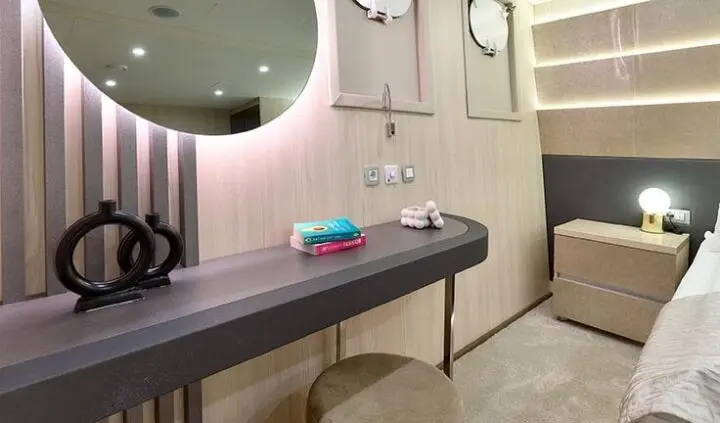 Interior cabin of Cristal yacht with a wooden desk, mirror, and seating area