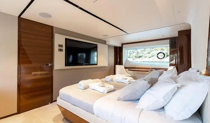 Vista yacht cabin with two neatly made beds and wood accents