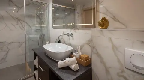 Onboard bathroom with marble shower walls and a modern sink on a yacht