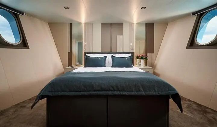 Ohana cabin with king bed, teal bedding, two bedside lamps, neutral walls