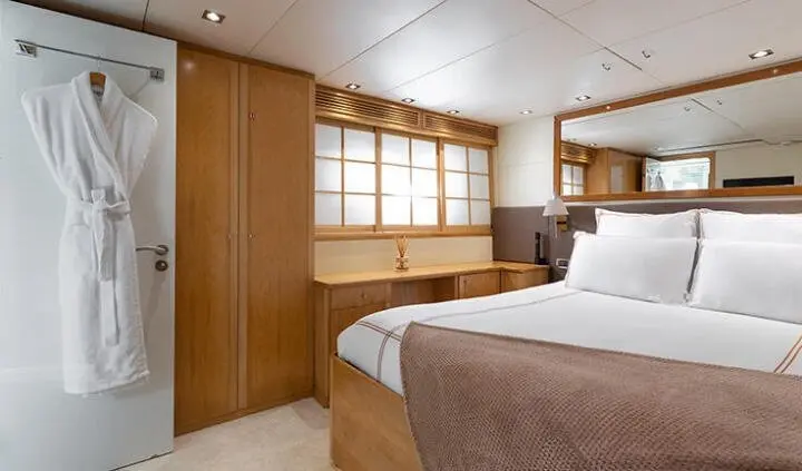 Cozy yacht cabin with double bed, wood-paneled walls, and built-in storage