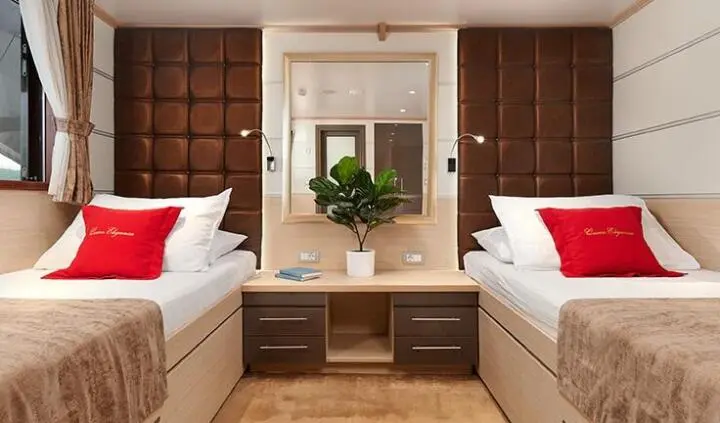 Twin cabin on Queen Eleganza yacht with two single beds and nightstands