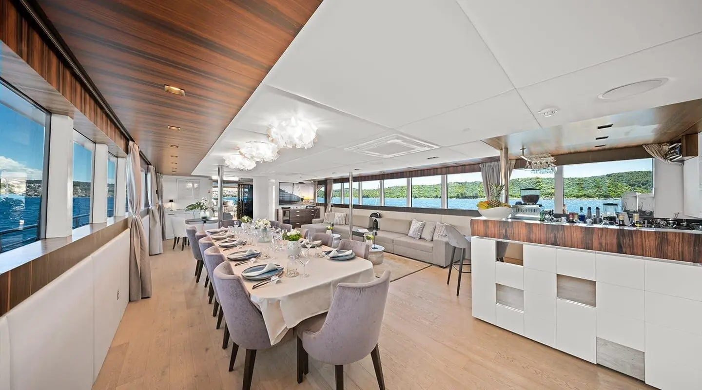 Dalmatino yacht dining area aboard with set tables, chairs, and large windows