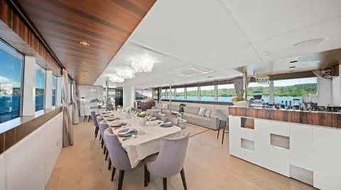 Dalmatino yacht dining area aboard with set tables, chairs, and large windows