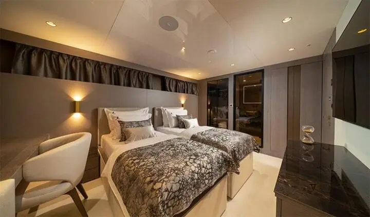 Nocturno yacht cabin with twin beds, ensuite, and warm lighting