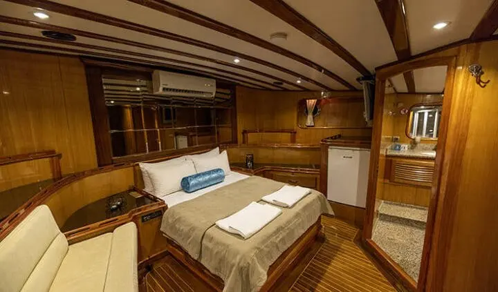 Luxurious master cabin with king bed, wood paneling, and en-suite