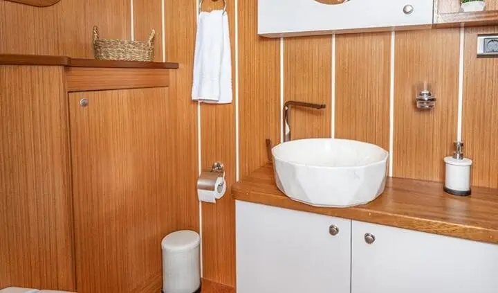 Cabin bathroom on Gozdem The One yacht with sink, mirror, and wooden walls