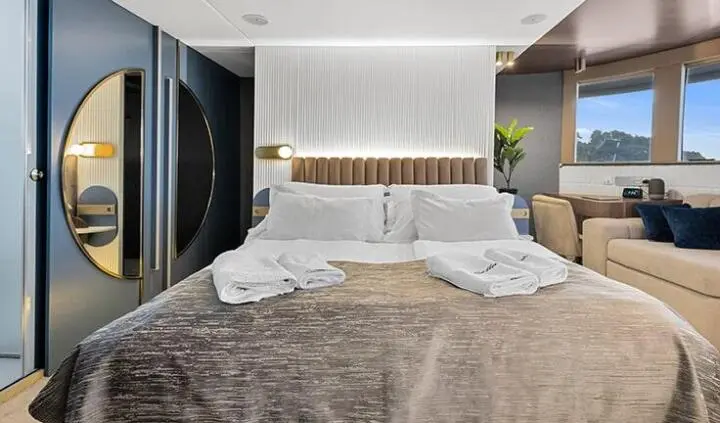 Bella yacht master cabin with king bed and white bedding, ensuite door visible