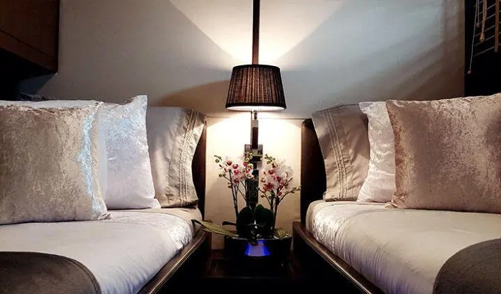 Twin cabin with king bed, pendant lamp, and plush pillows on headboard