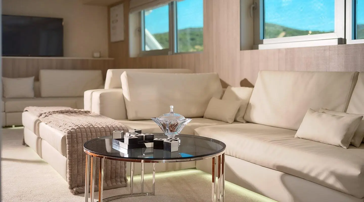 Elegant salon on Cristal yacht with beige seating and glass coffee table