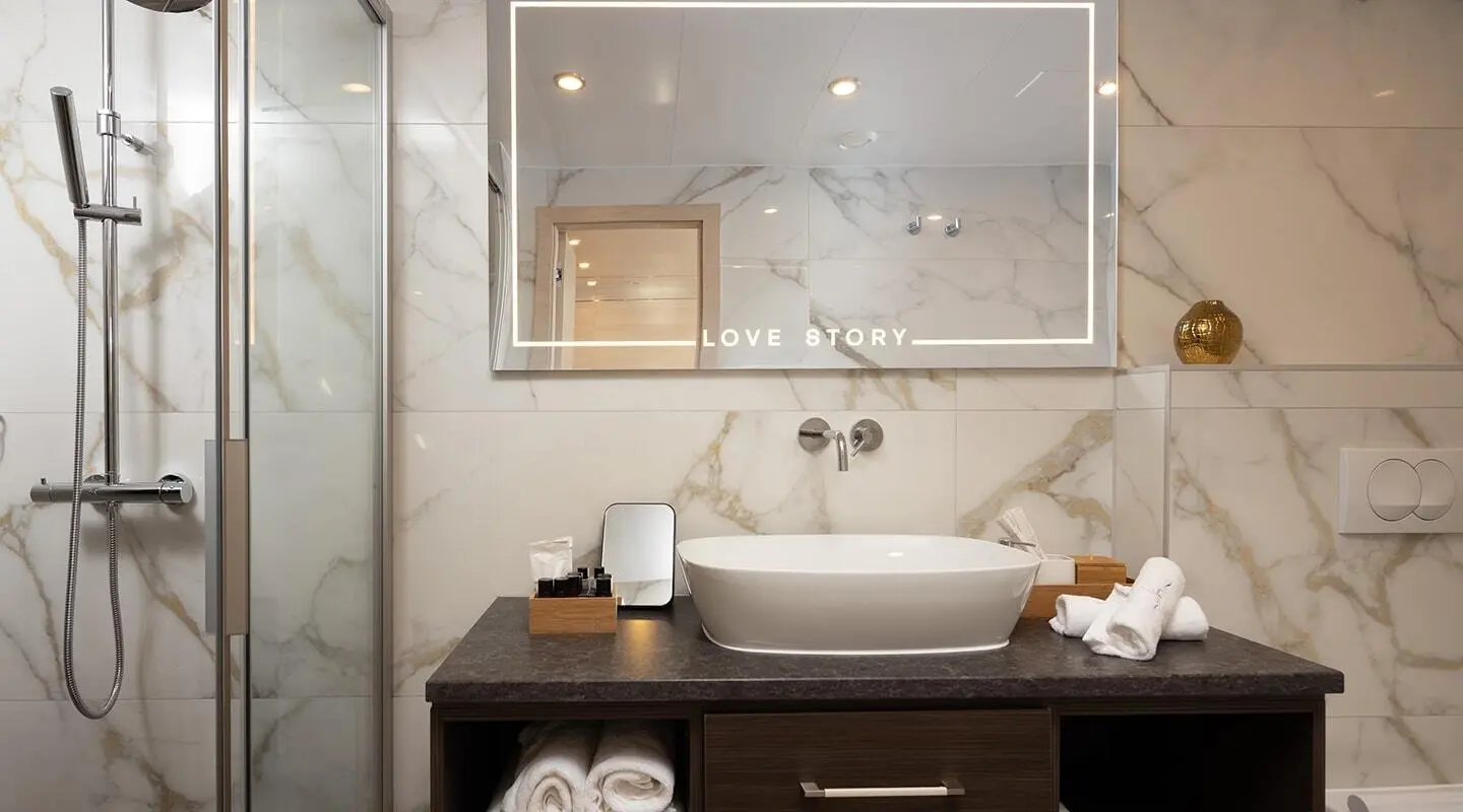 Love Story yacht interior scene with sink, mirror, and toiletries on a wooden vanity
