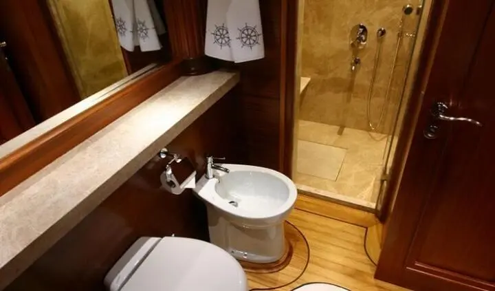 Master cabin with king bed, en-suite bathroom, wood paneling and doorway