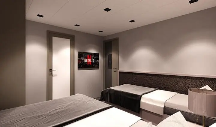 Twin cabin with two single beds, ensuite bathroom, neutral lighting