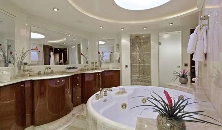 Master cabin with king bed, ensuite, portholes, and wooden cabinetry