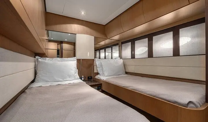Interior of yacht cabin with wooden cabinetry, built-in seating, and porthole windows