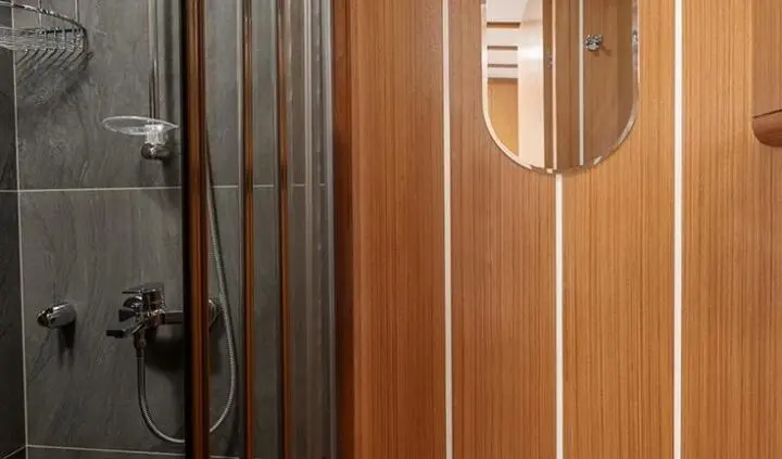 Master cabin with king bed, wooden paneled walls and ensuite doorway