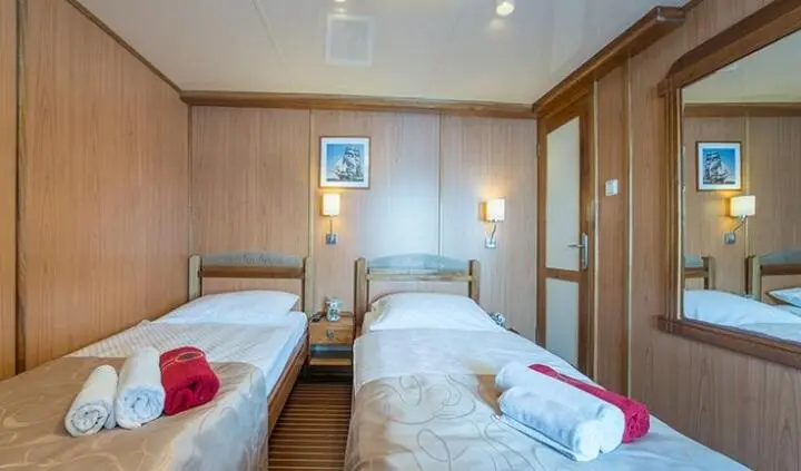 Twin cabin on Barbara yacht with two single beds and bedside tables