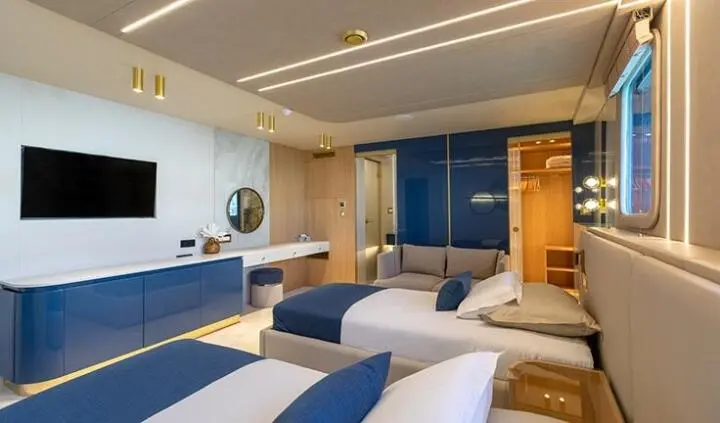Twin cabin ensuite bed on Scorpios yacht interior with blue accents