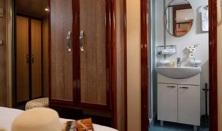 Inside Mendula cabin, wooden wardrobe, door, and a view toward deck