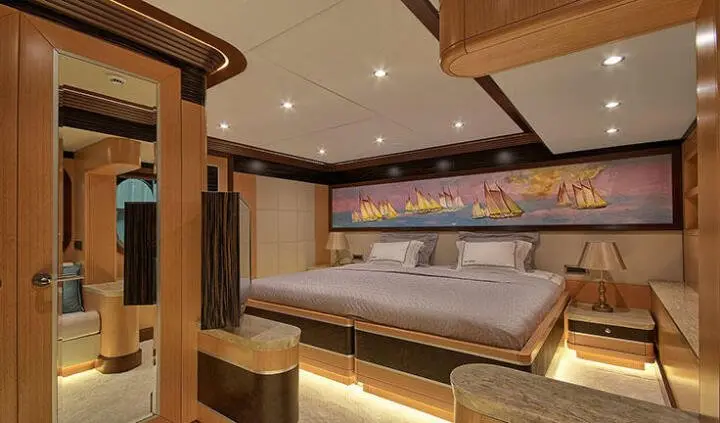 Meira yacht master cabin with king bed, ensuite visible in warm lighting