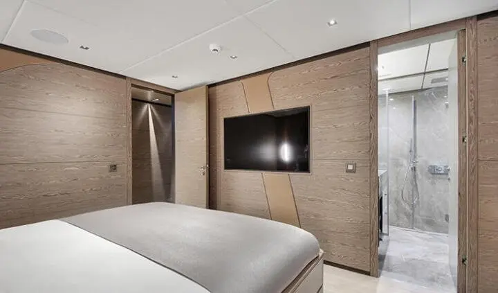 Twin cabin with woodPanelled walls, bed, and wall mounted TV screen