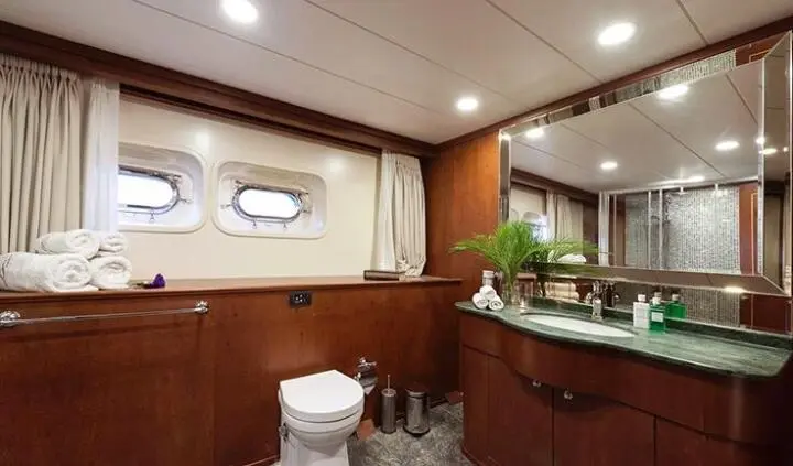 Ocean Breeze cabin interior with wood panels, seating, and small window view