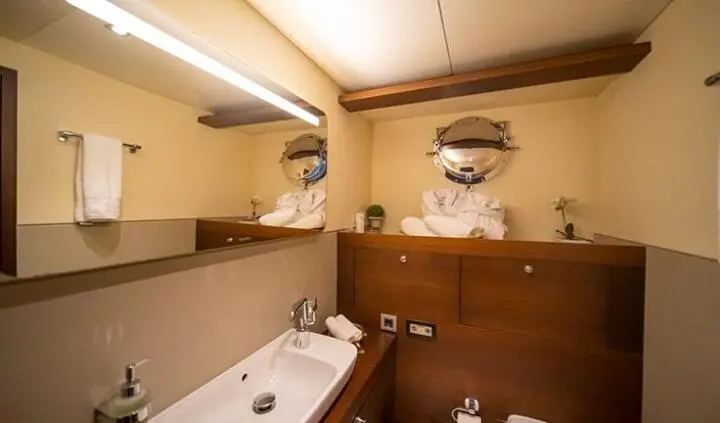 Cabin bathroom on Double Eagle yacht with bathtub, sink, and wooden paneling