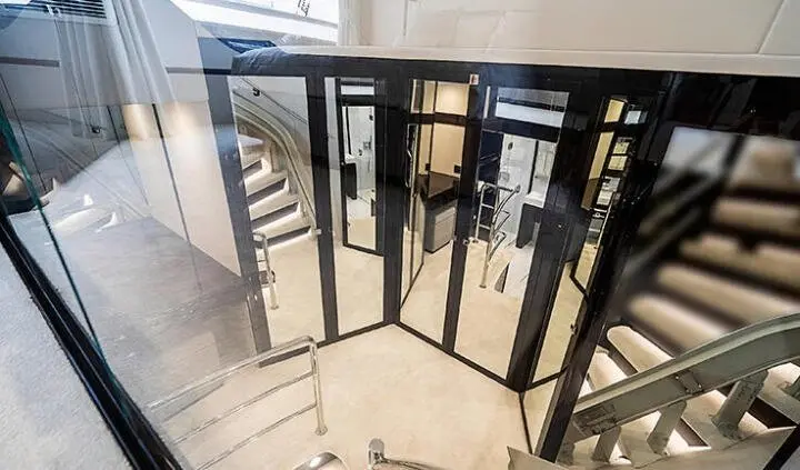 Quantum yacht cabin with king bed, ensuite visible through glass doors