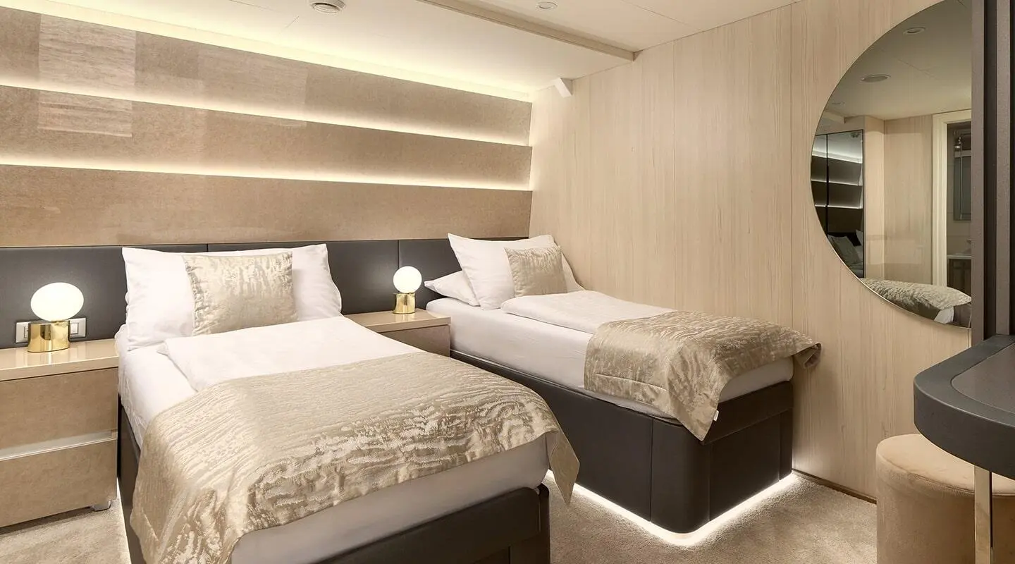 Interior of Cristal luxury yacht with two beds, modern lighting, and beige decor