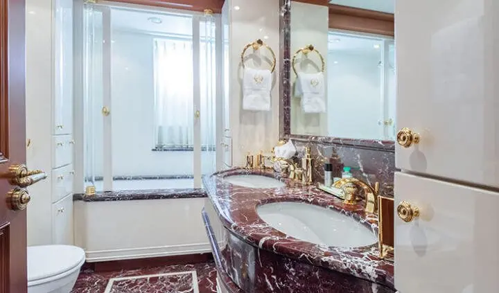 Interior cabin bathroom with marble countertop, sink, and elegant fixtures
