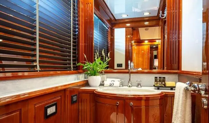 Master cabin with king bed and ensuite bathroom on Divine yacht, wood cabinetry