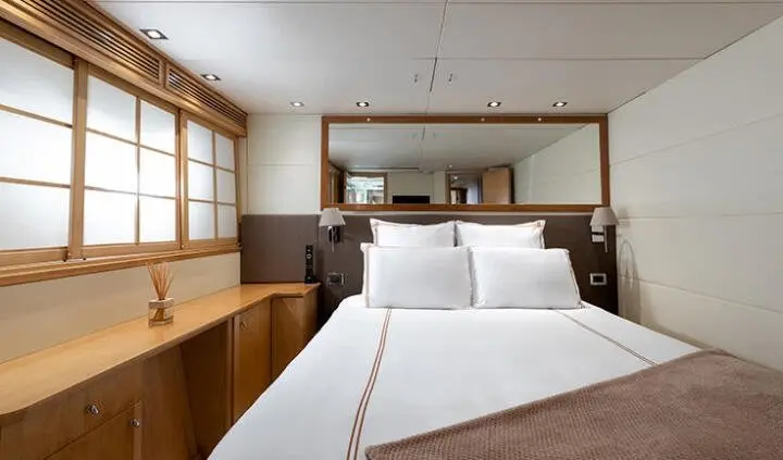 Yawning double cabin with two single beds and a shared headboard, window light