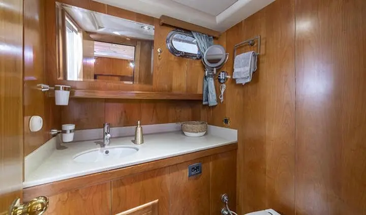 Queen Of Sea master cabin with king bed, wood panels, ensuite glimpse