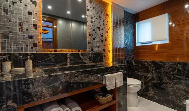Master cabin with ensuite bathroom featuring dark marble, wooden accents, and bright window