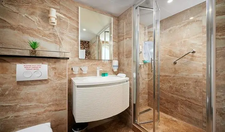 Queen Eleganza cabin ensuite with white circular sink and glass shower