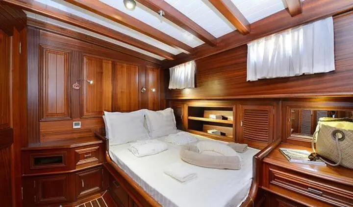 Cozy cabin aboard Samarkand yacht with wooden paneling and bed