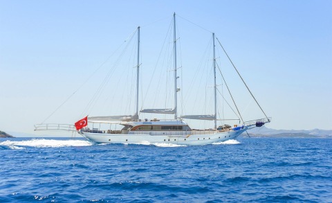 Sailing yacht with three masts on blue sea, Turkish flag at stern