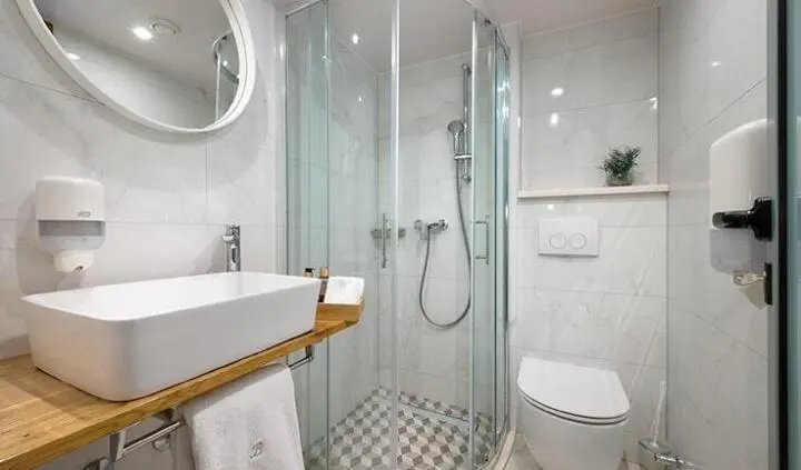 Master cabin with king bed, ensuite shower, and compact bathroom fixtures