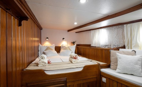Lux wooden cabin with double bed on a yacht interior