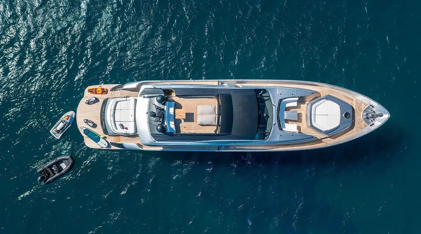 Top-down view of a sleek motor yacht named One sailing calm blue sea