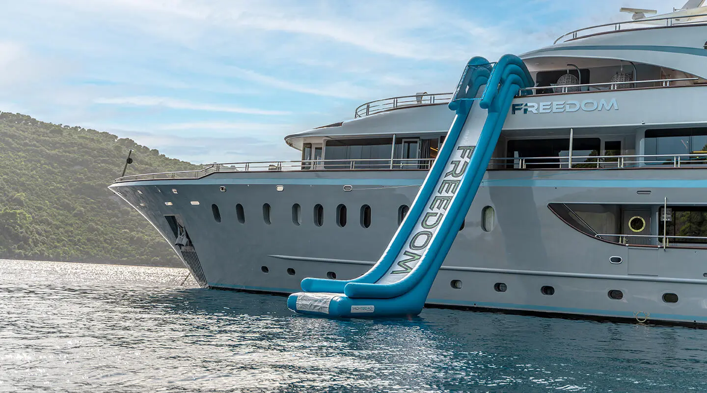 Yacht Freedom with a blue water slide extended over the water