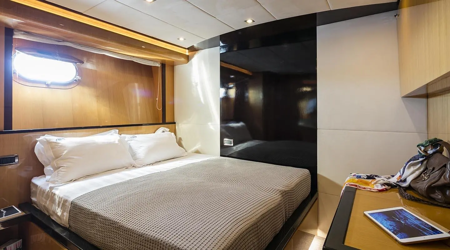 Luxurious yacht bed with white linens and wood accents on ship