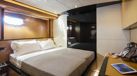 Luxurious yacht bed with white linens and wood accents on ship