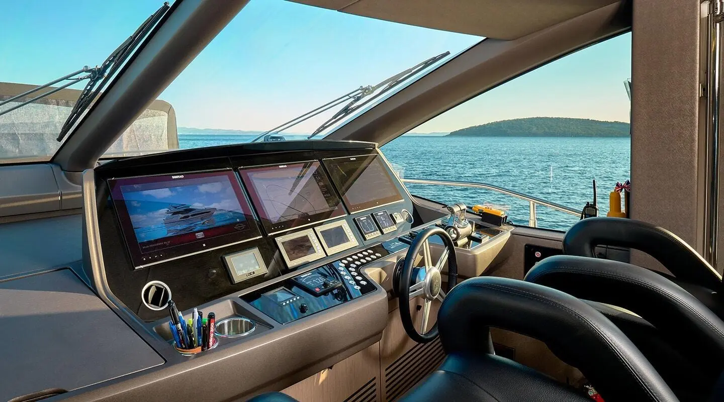 Yacht cockpit on Calm sea at sunset with steering wheel and navigation screens