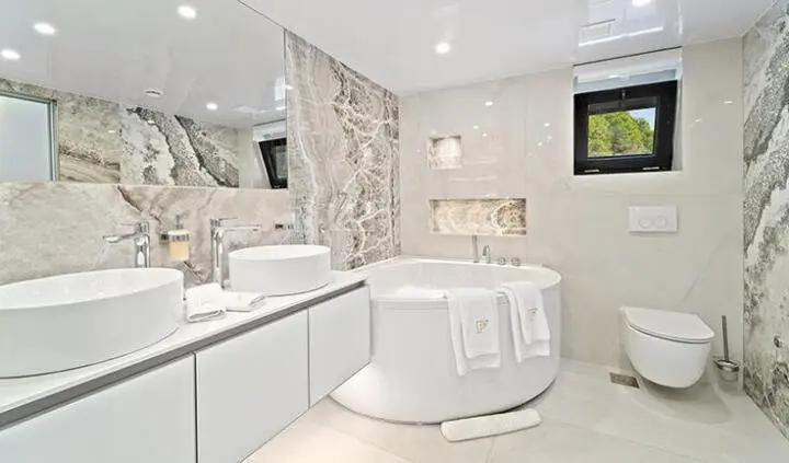 Interior cabin with a large round tub, light walls, and modern furnishings on Freedom yacht