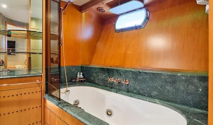 Mobius yacht cabin with king bed, wood paneling, and ensuite bath view