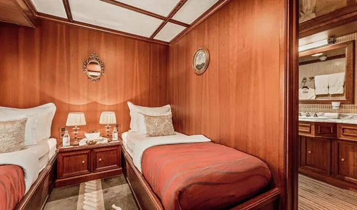 Cozy cabin with twin beds, wood-paneled walls, and soft lighting on Seagull II