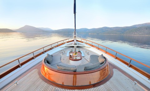 Cobra King yacht bow seating on deck with cushioned lounge and table overlooking calm sea