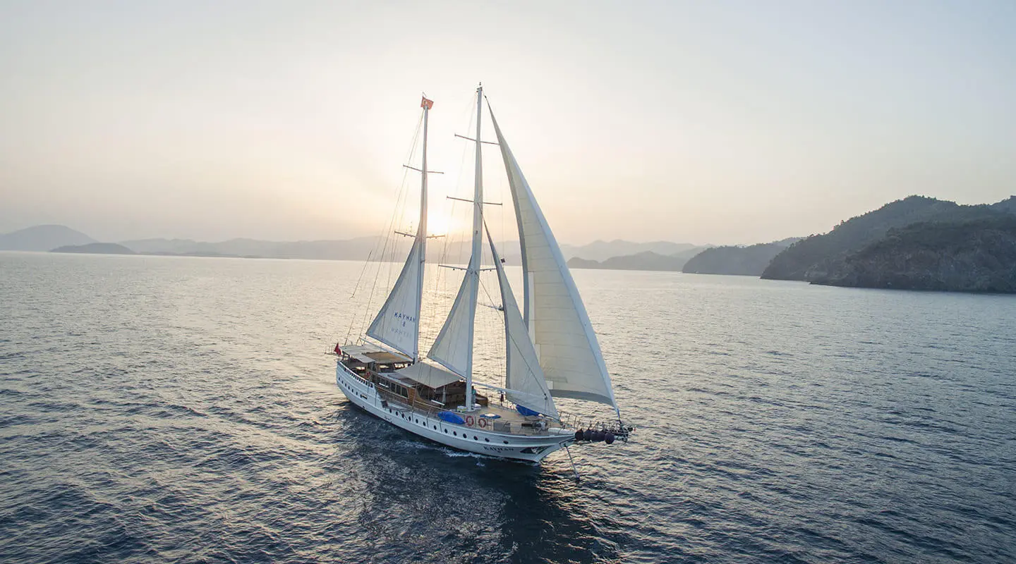 Two-masted luxury yacht Kayhan 8 sailing on calm sea at sunset