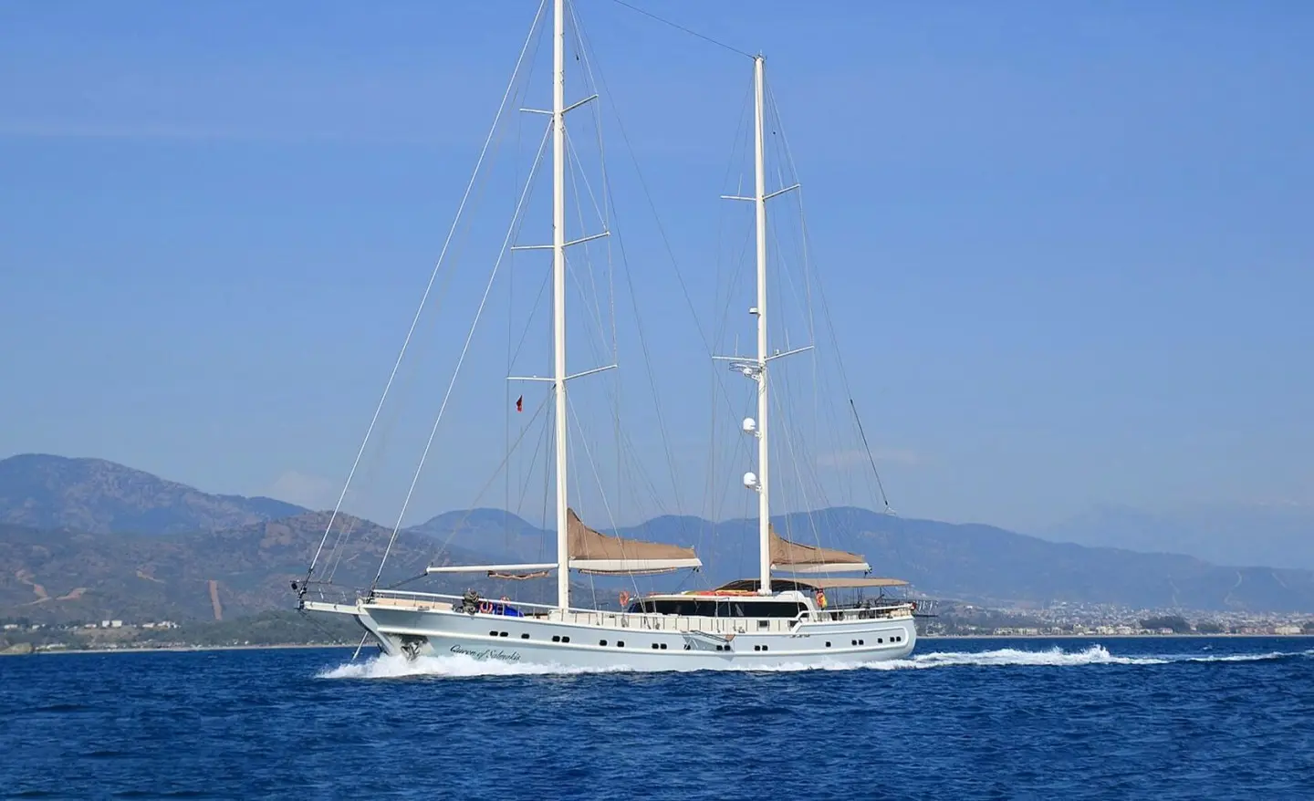 Queen Of Salmakis yacht sailing on calm blue sea at sunset